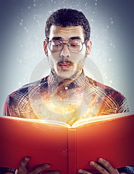 Thinking, glowing book and man with story, fantasy and education on grey studio background. Person, model and guy with