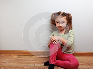 Thinking humor girl sitting on the floor with fun look