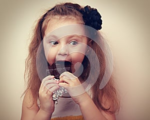 Thinking kid with humor look eating chocolate. Vintage