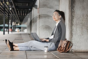 Thinking, laptop and woman on a coffee break in the city or employee typing on social media, internet or online job