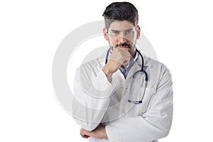 Thinking male doctor studio portrait while standing at isolated white background