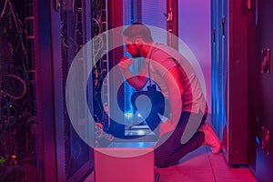 Thinking man crouched near open servir rack photo