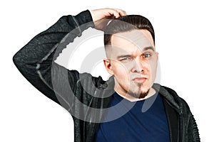 Thinking man holds hand at face, isolated on white background. Closeup portrait of young pensive guy. Caucasian male model