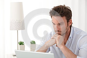 Thinking man with laptop photo