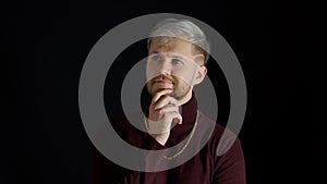 Thinking man looking up and around contemplating how to solve problem against black background