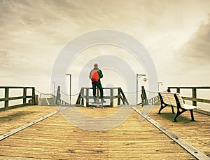 Thinking man on wooden pier on background of sea