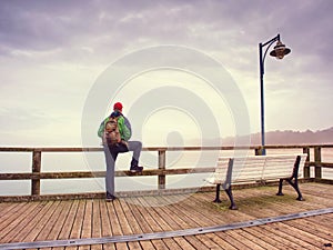 Thinking man on wooden pier on background of sea