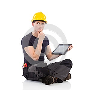 Thinking manual worker posing with a digital tablet