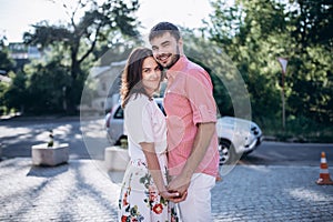 Thinking about new place to go. Beautiful young smiling couple hold hands each other. Looking to the camera