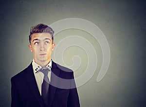 Thinking perplexed man wondering looking up solving a problem