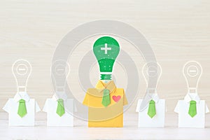Thinking positive concept, Origami yellow shirt with tie and light bulb with positive and negative thinking on wooder background