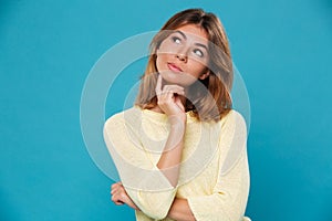 Thinking pretty woman over blue background photo