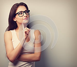 Thinking professional woman in glasses looking with finger under