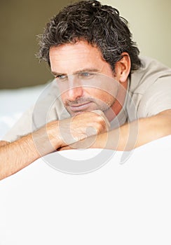 Thinking, relax and mature man in bed in the morning after nap, break or comfortable sleep at home. Smile, idea and male