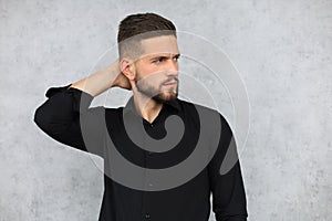 Thinking serious young handsome man is posing isolated over grey background