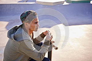 Thinking, skateboard and man at a skate park with idea for trick, stunt or adrenaline sports action. Planning, calm and