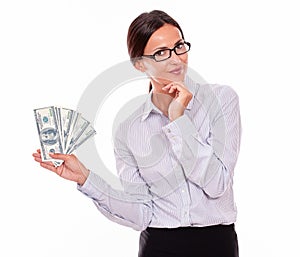 Thinking smiling brunette businesswoman with money