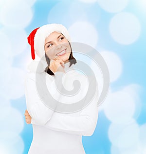 Thinking and smiling woman in santa helper hat