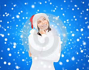 Thinking and smiling woman in santa helper hat