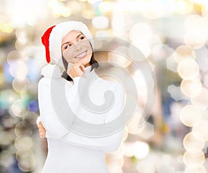 Thinking and smiling woman in santa helper hat