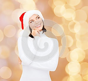 Thinking and smiling woman in santa helper hat