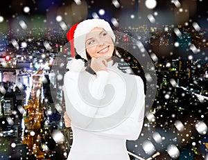 Thinking and smiling woman in santa helper hat
