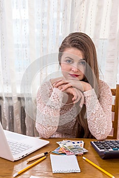 Thinking woman analyzing her profit in euro