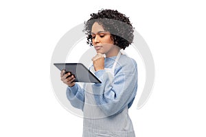 thinking woman in apron with tablet pc computer