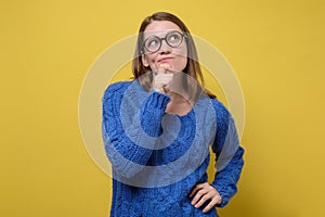 Thinking woman in blue sweater pondering over something important.