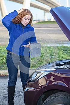 Thinking woman with opened car cowling