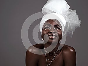 Thinking, wrap and black woman with makeup, smile and beauty in studio on grey background. Fashion, turban or African