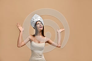 Thinking young woman in kokoshnik hat looking up on many questions over beige background. ,