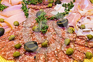 Thinly sliced ham and salami with greens.