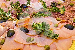 Thinly sliced ham and salami with greens.