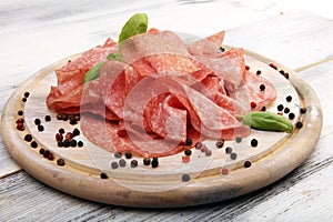 thinly sliced salami, delicious snack rustic salami on table