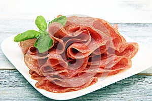 thinly sliced salami, delicious snack rustic salami on table