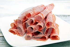 thinly sliced salami, delicious snack rustic salami on table