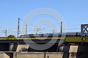 Thionville, France - 08 22 2023: Old railroad bridge with a fast train