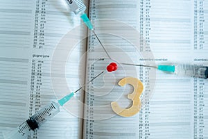 Third covid vaccine dose and jab concept. Three syringes are seen on calendar as a concept for the 3rd covid-19 vaccine dose, also