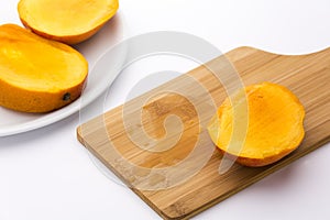 Third Of A Mango And Its Juice On Wooden Board