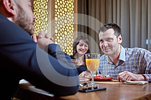 The third is superfluous. couple in love is having dinner in a restaurant with a lonely friend photo