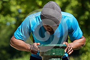 Thirsty african american man drinking water