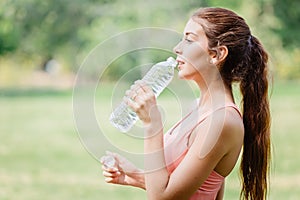 Thirsty beautiful sport women model handle drink clean drinking water outdoor after exercise