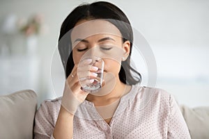 Thirsty biracial woman drink water from glass