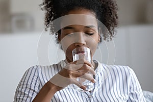 Thirsty ethnic woman drink clean water from glass