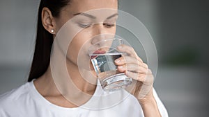 Thirsty female drinking pure water from glass