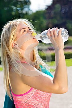 Thirsty fit woman gulping down water from bottle photo