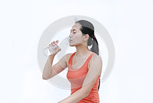 Thirsty fitness girl drinking bottle of water