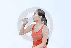 Thirsty fitness girl drinking bottle of water