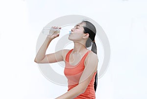 Thirsty fitness girl drinking bottle of water